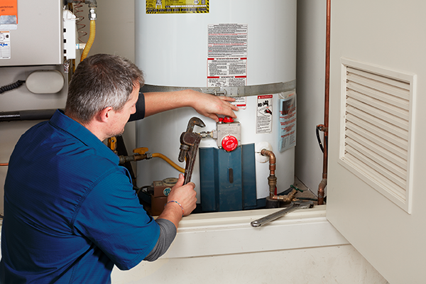 Technician installing a new residential water heater in a Green Bay utility room